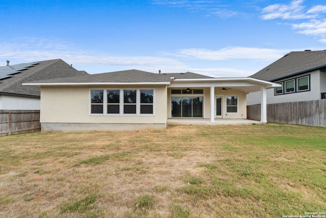 rear view of property featuring a patio area and a yard