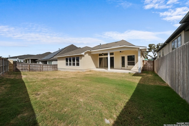 back of house with a patio area, a yard, and ceiling fan