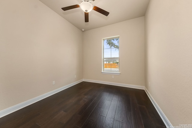 empty room with dark hardwood / wood-style floors, vaulted ceiling, and ceiling fan