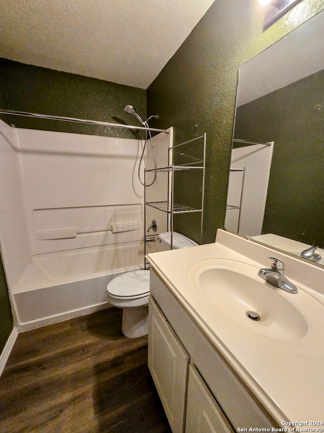 full bathroom featuring vanity, hardwood / wood-style flooring, toilet, a textured ceiling, and shower / bathtub combination