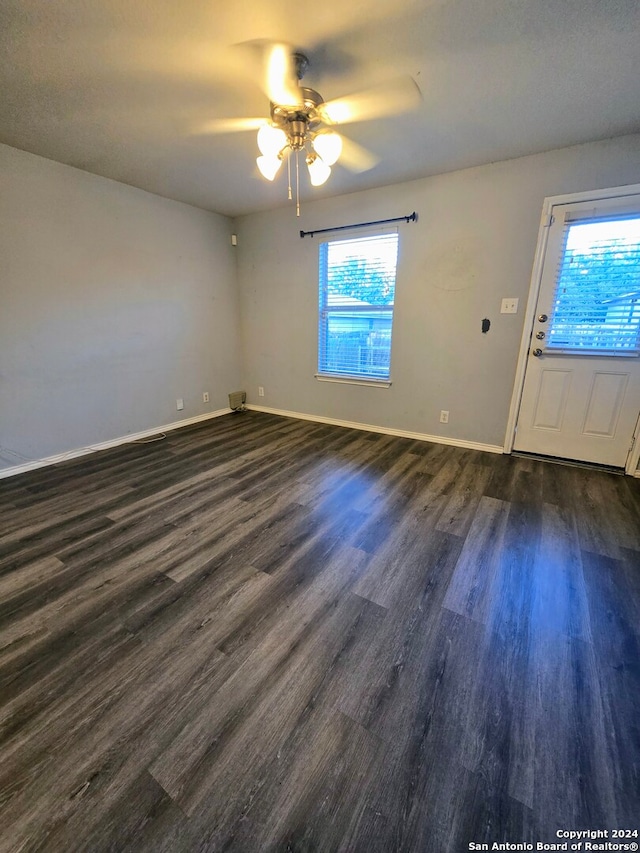 unfurnished room with dark hardwood / wood-style flooring, plenty of natural light, and ceiling fan