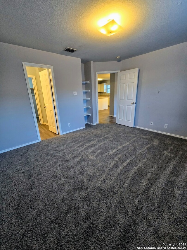 unfurnished bedroom featuring carpet and a textured ceiling