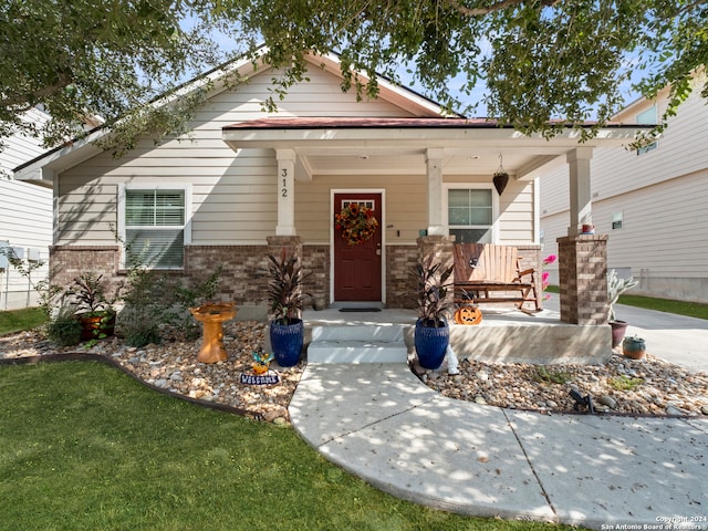 view of front of home with a porch and a front yard