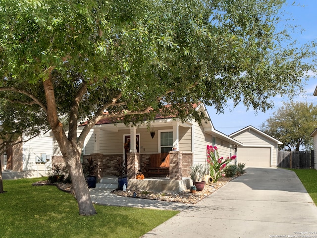 view of front of home featuring a front yard, a garage, and covered porch