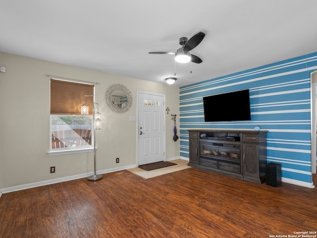 unfurnished living room featuring ceiling fan, a fireplace, and dark hardwood / wood-style flooring