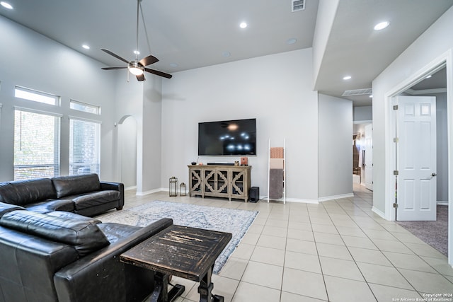 living room with light tile patterned floors, a high ceiling, and ceiling fan