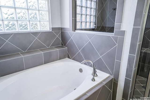 bathroom featuring separate shower and tub