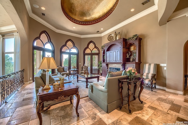 living room with crown molding, a towering ceiling, and french doors