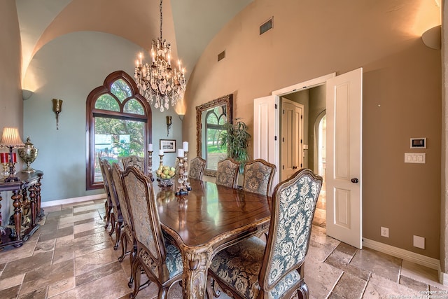 dining space featuring an inviting chandelier and high vaulted ceiling