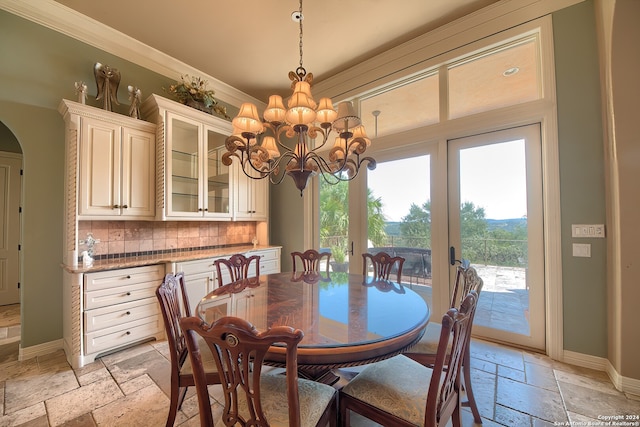 dining space with an inviting chandelier and ornamental molding