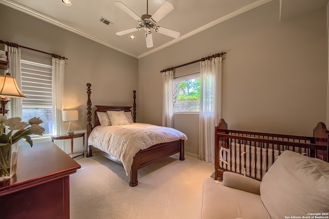 bedroom with ceiling fan, crown molding, and light colored carpet