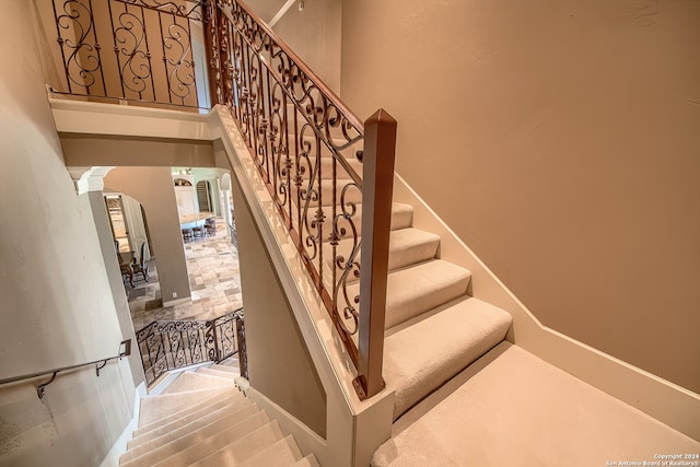 stairway featuring decorative columns