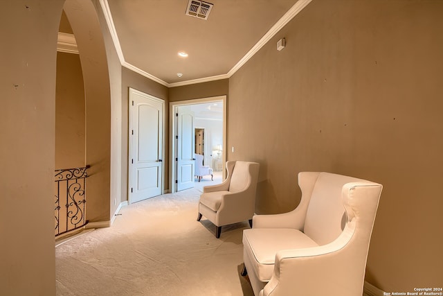 living area with crown molding and light colored carpet