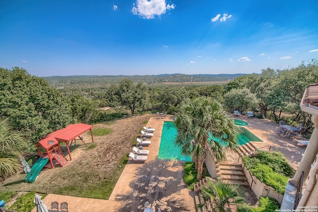 view of pool with a patio area and a playground