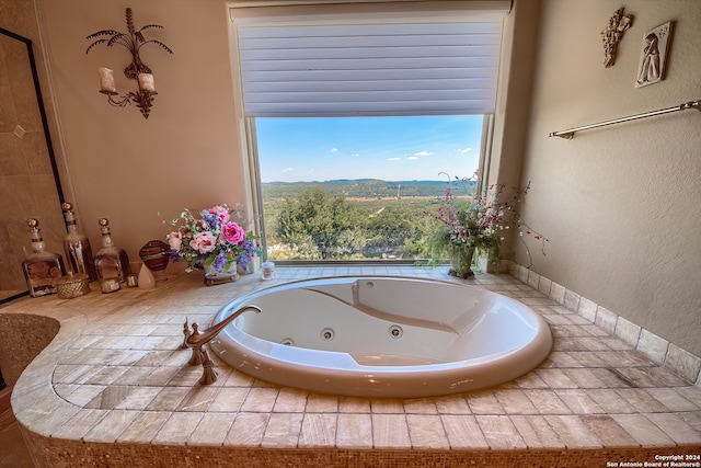 bathroom featuring a mountain view and a relaxing tiled tub