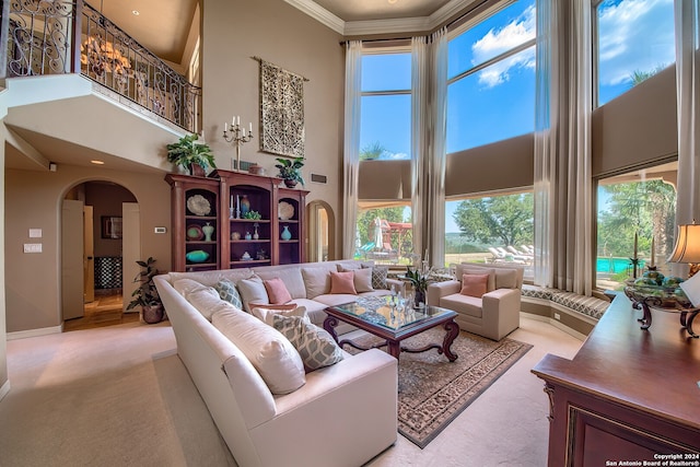 living room featuring crown molding, light carpet, and a towering ceiling