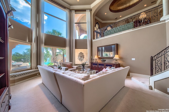 living room with a towering ceiling, crown molding, and light colored carpet