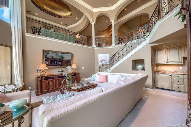 living room featuring crown molding and a high ceiling