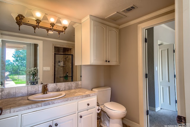 bathroom featuring a shower with door, vanity, ornamental molding, and toilet