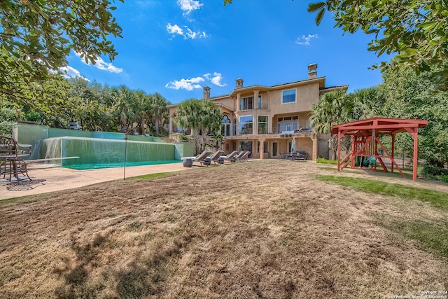 exterior space featuring a patio area, a playground, a yard, and a pool