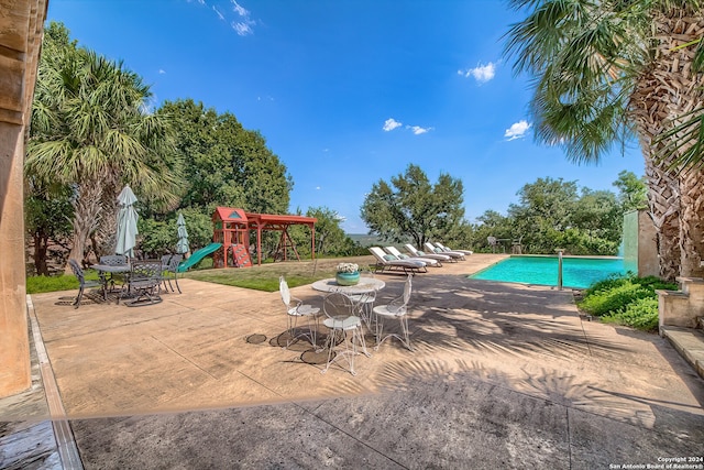 view of pool with a patio area and a playground