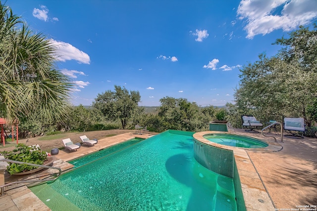 view of swimming pool featuring an in ground hot tub and a patio area