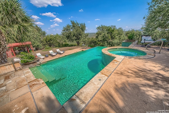 view of swimming pool featuring an in ground hot tub and a patio