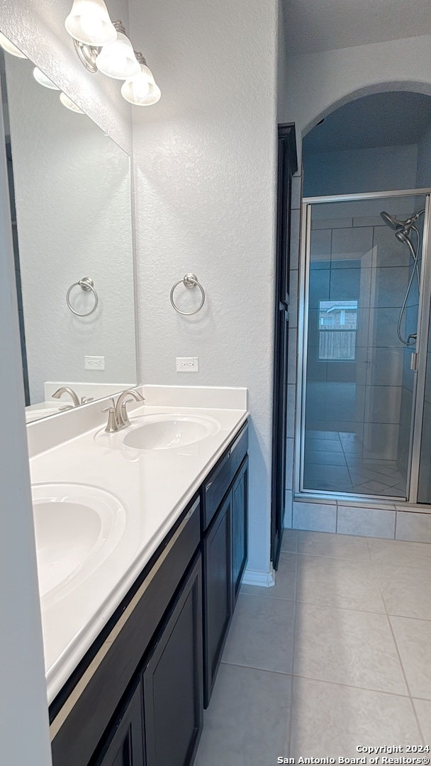 bathroom featuring vanity, walk in shower, and tile patterned flooring