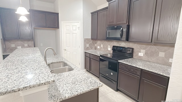 kitchen featuring sink, black appliances, an island with sink, and hanging light fixtures