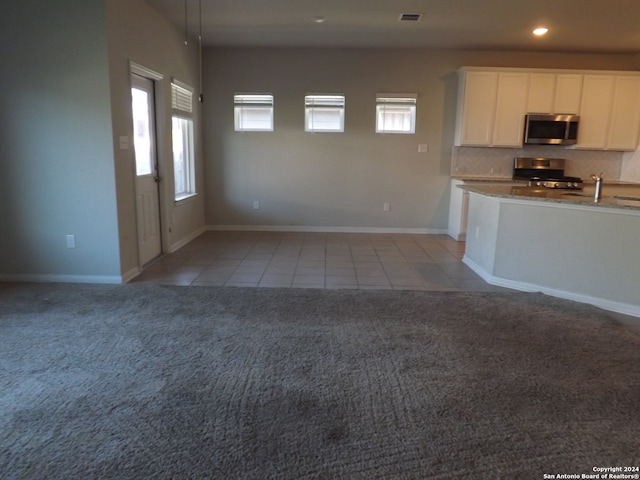 kitchen featuring light carpet, white cabinets, light stone countertops, sink, and stainless steel appliances