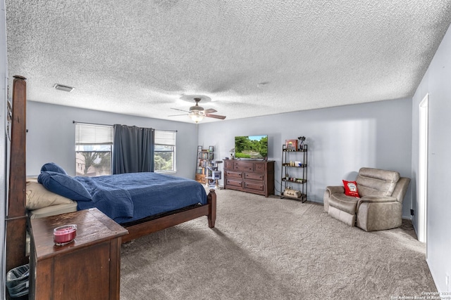 carpeted bedroom featuring ceiling fan and a textured ceiling