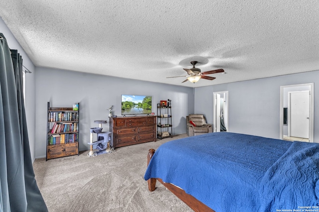 carpeted bedroom featuring ensuite bathroom, a textured ceiling, and ceiling fan