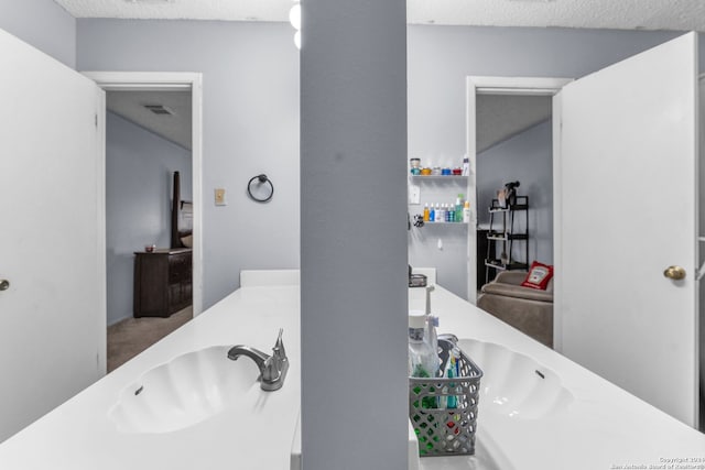 bathroom with a textured ceiling and sink