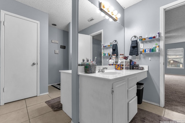 bathroom with vanity, a textured ceiling, and tile patterned flooring