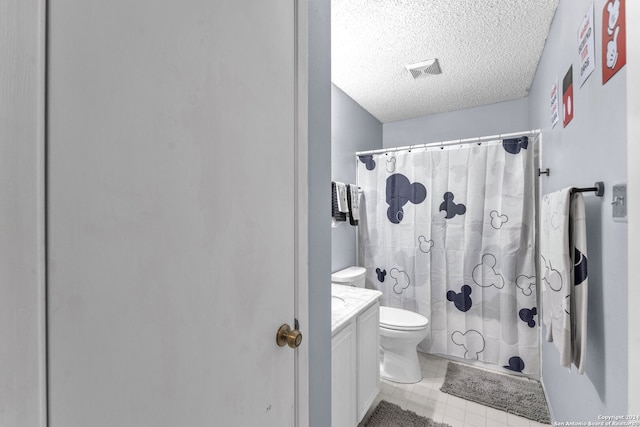 bathroom featuring tile patterned floors, toilet, a shower with curtain, vanity, and a textured ceiling