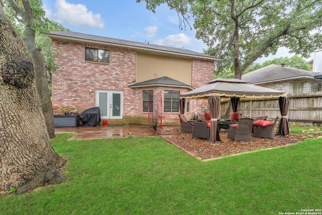 rear view of property featuring a patio, a gazebo, and a yard