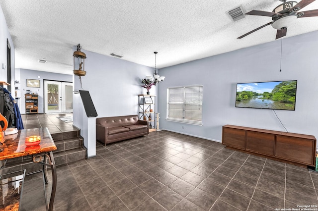 tiled living room with a textured ceiling and ceiling fan with notable chandelier