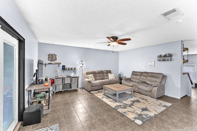 tiled living room featuring a textured ceiling and ceiling fan