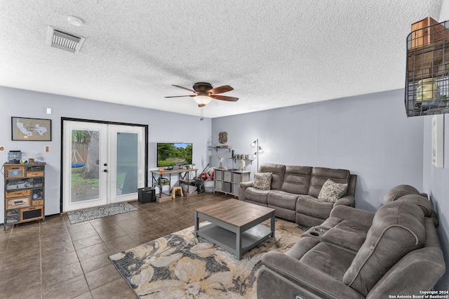 living room featuring french doors, ceiling fan, a textured ceiling, and dark tile patterned floors