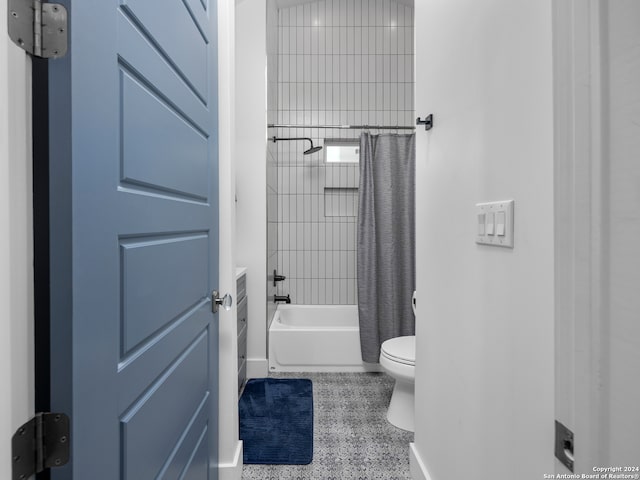 bathroom featuring toilet, tile patterned flooring, and shower / tub combo with curtain