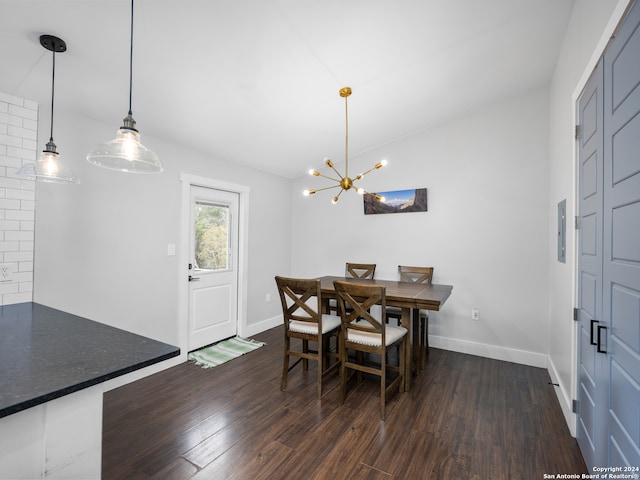 dining space with a chandelier, vaulted ceiling, and dark hardwood / wood-style flooring