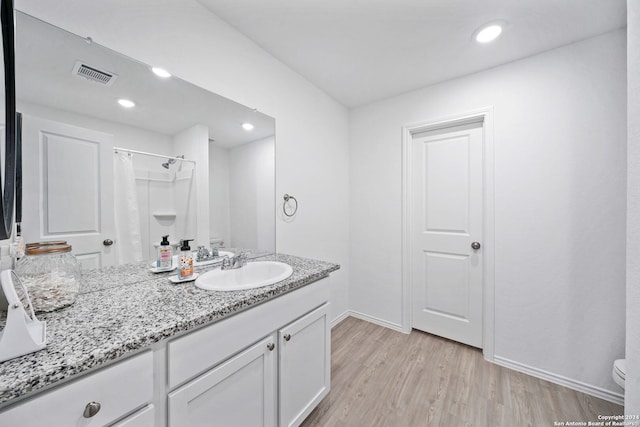 bathroom with vanity, toilet, hardwood / wood-style flooring, and curtained shower