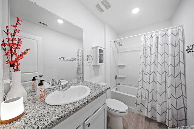 full bathroom featuring vanity, shower / bath combo with shower curtain, hardwood / wood-style flooring, and toilet