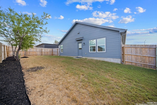 rear view of property featuring a lawn