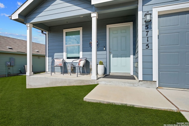 entrance to property featuring a porch and a yard