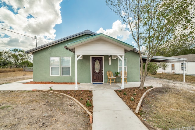 bungalow-style home with a carport and a porch