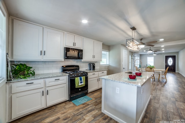 kitchen featuring white cabinetry, black appliances, a center island with sink, and dark hardwood / wood-style flooring