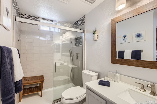 bathroom with vanity, toilet, a textured ceiling, and an enclosed shower