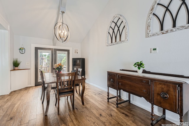 dining area featuring hardwood / wood-style floors, high vaulted ceiling, and an inviting chandelier