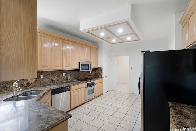 kitchen with appliances with stainless steel finishes, light brown cabinets, decorative backsplash, and sink